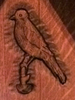 Vogel auf Grabkreuz