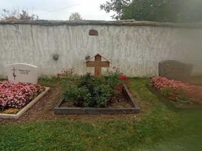 Grabkreuz neben Grabsteinen